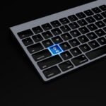 a black keyboard with a blue button on it